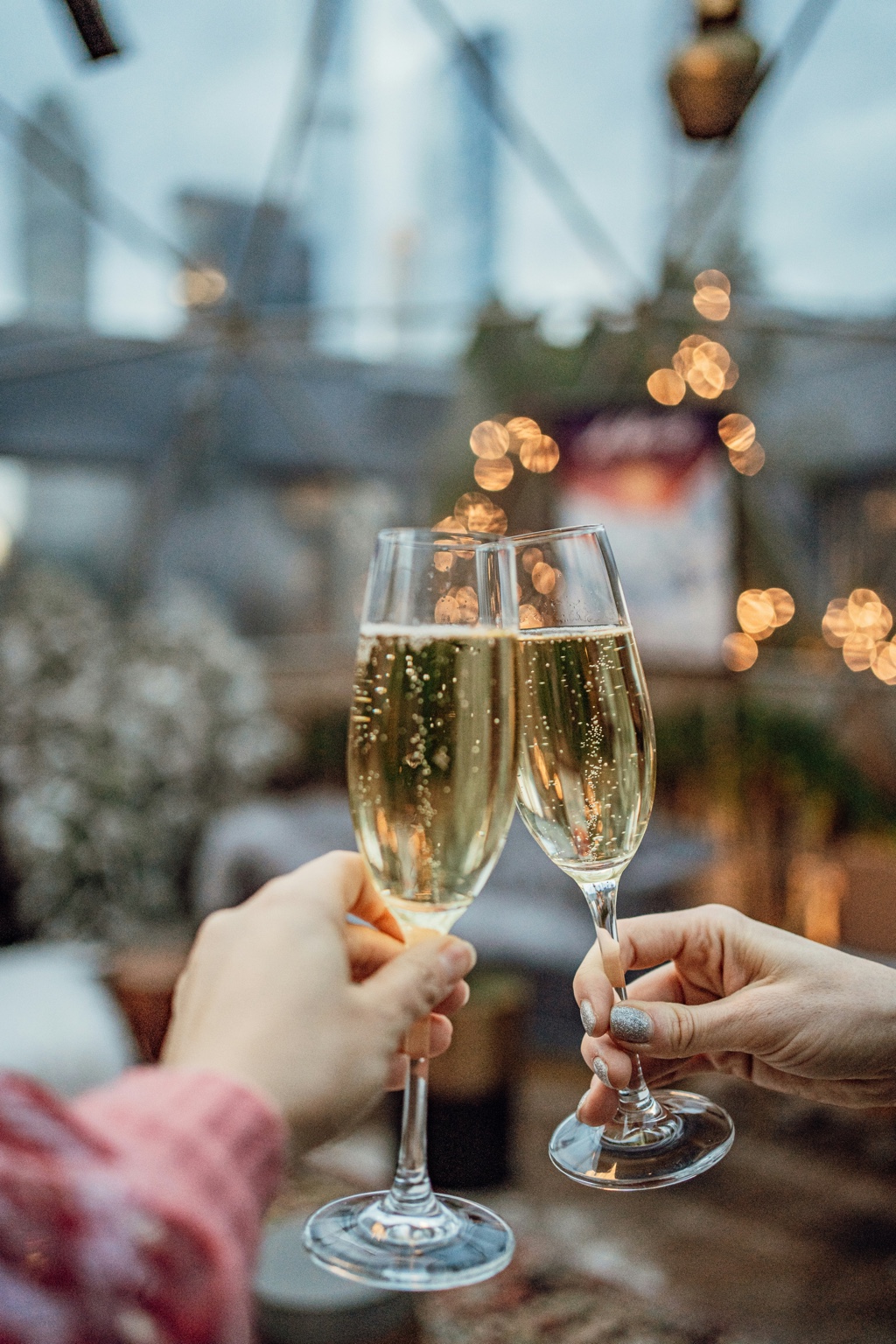 Champagne toast with holiday lights